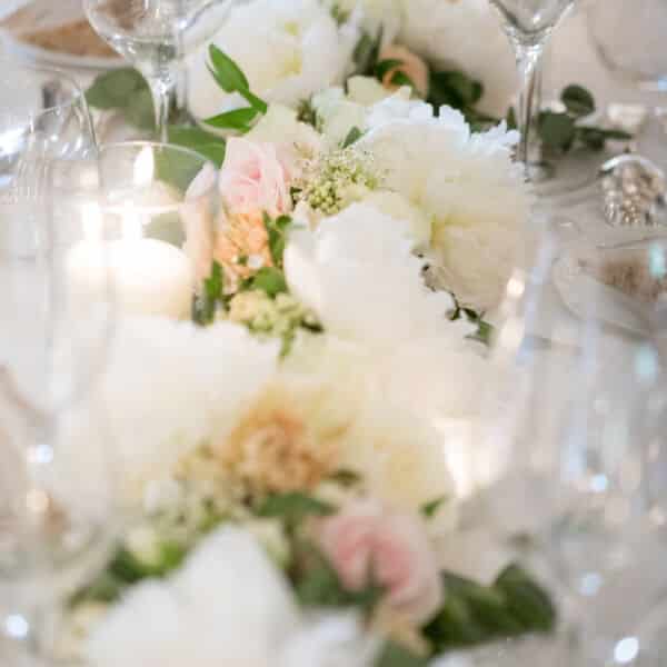 décoration de table fleuri, blanc et feuillage.